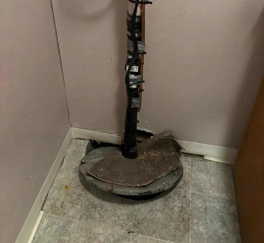 Technicien réparant une pompe de puisard dans un sous-sol à Brossard